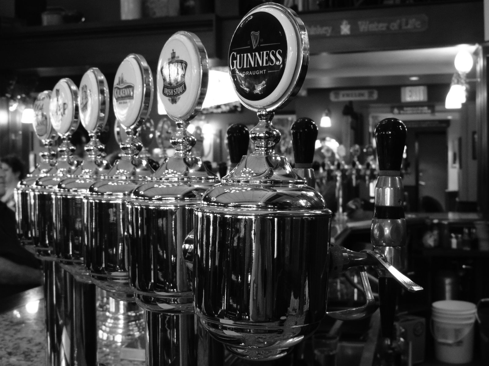 A row of polished draught taps along Clancy's bar, Guinness front and centre
