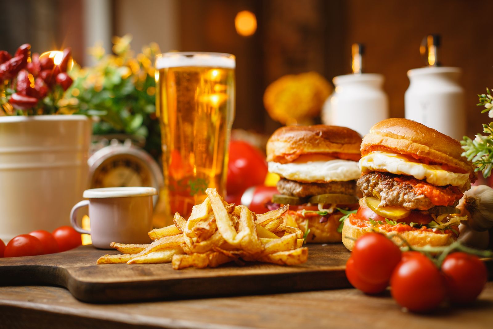 Stacked pub burgers and a basket of fries beside a cold pint at Clancy's